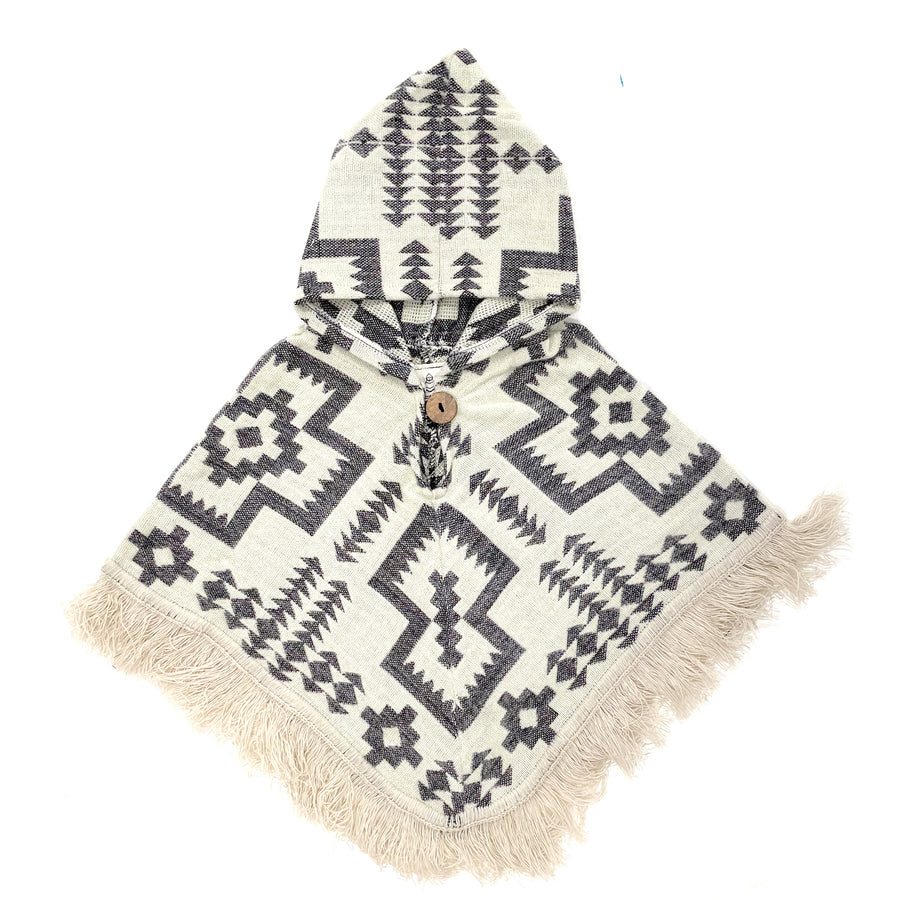 front of baby poncho with hood and fringe with a base cream color and a pattern of crosses and arrows and stars in a lavender color 