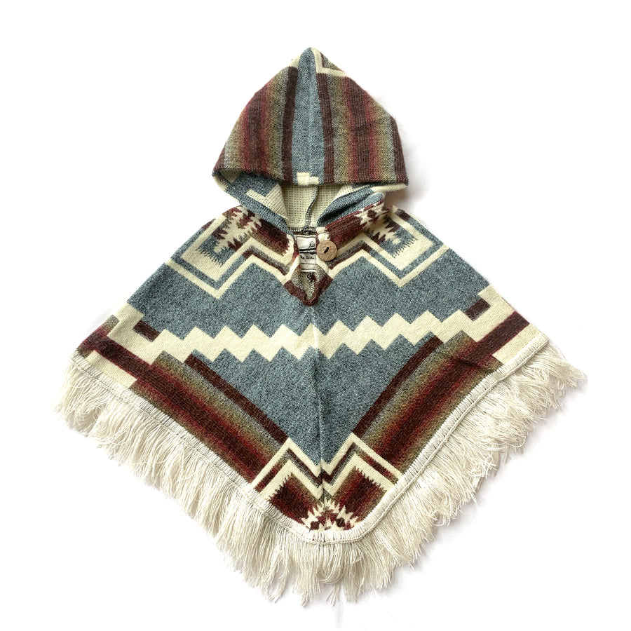 front of baby and toddler poncho with hood and fringe with color light blue and brown and orange with some white patterns on top