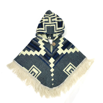 front of baby poncho with a hood in a denim like blue with white designs of staggered shapes and crosses